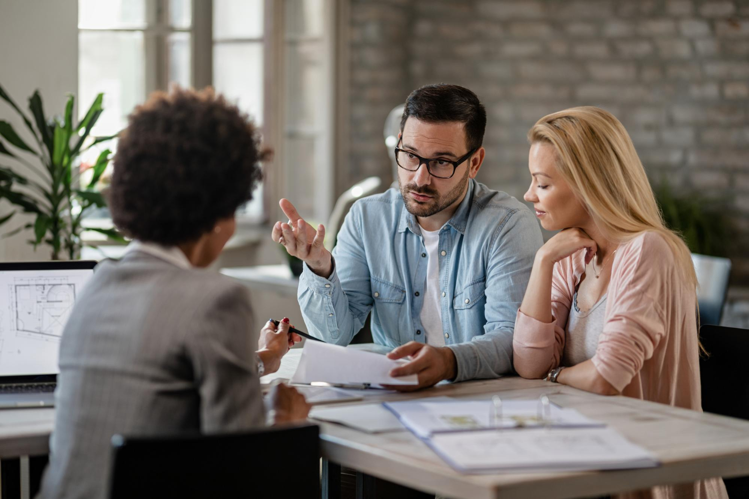 mid-adult-couple-discussing-with-financial-advisor-while-analyzing-documents-meeting-office